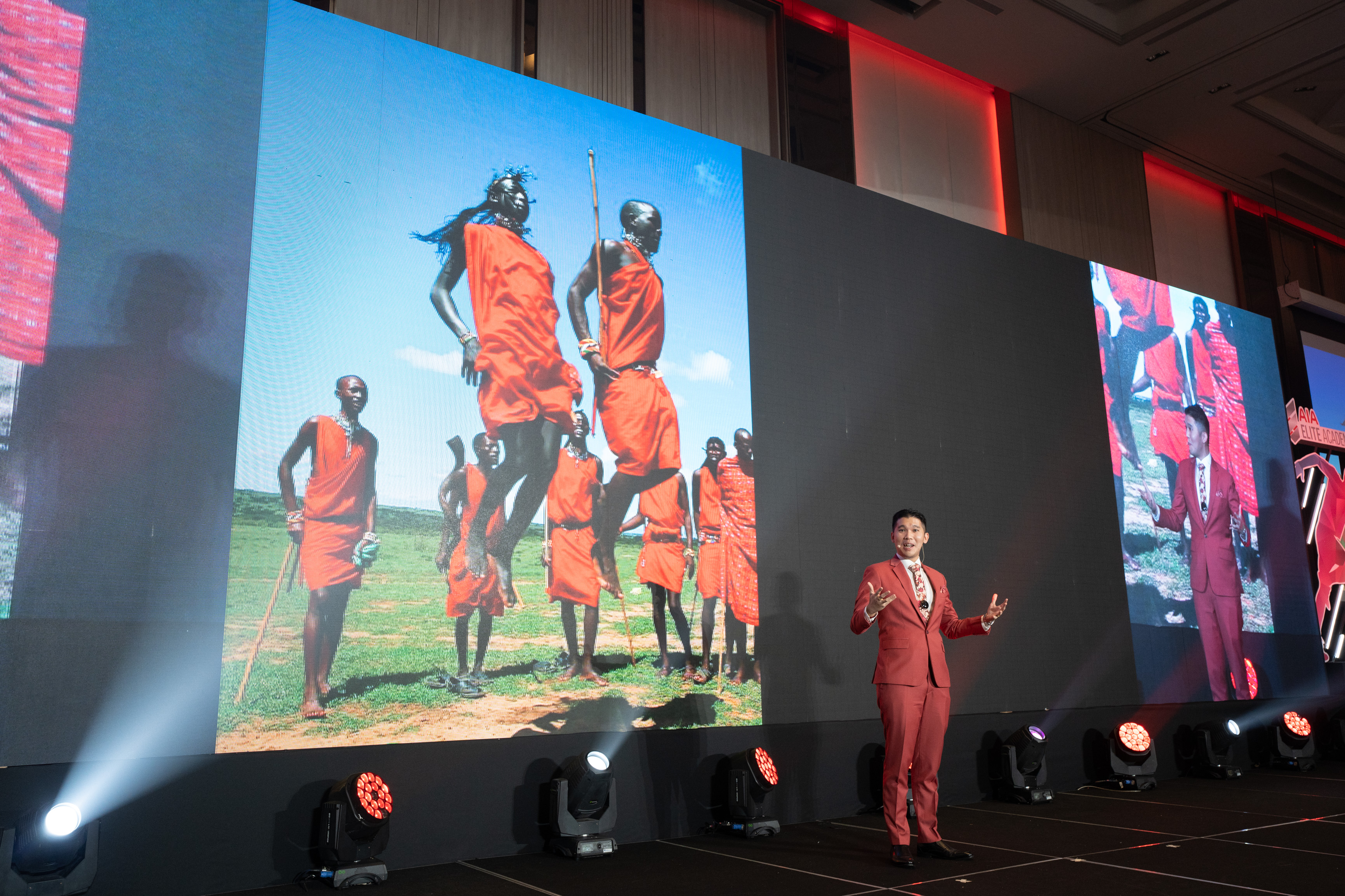 Michael Teoh delivering a keynote on a large conference stage